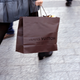 A woman walks with a Louis Vuitton shopping bag as she leaves a Louis Vuitton store in Paris.